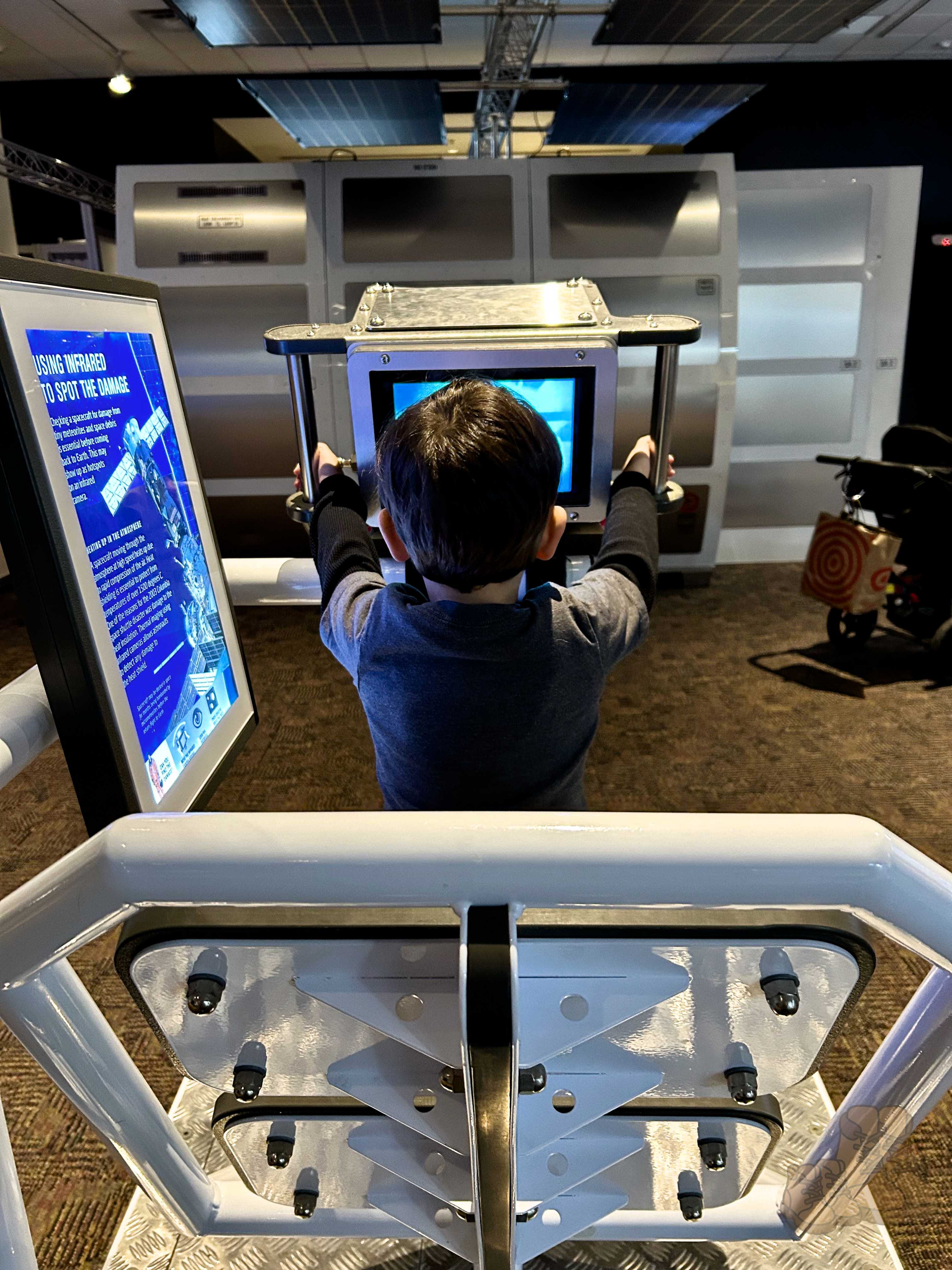 A little boy sitting at an astronaut simulation machine at Rochester Museum & Science Center